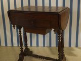 a small wooden table with a drawer on top of it