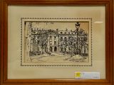 un dessin à l'encre représentant un bâtiment, encadré et posé sur une table