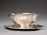an antique silver plate with a saucer and a saucer on it