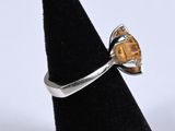 a close up of a silver ring with a citrine stone