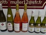 Plusieurs bouteilles de vin sont alignées sur un comptoir devant une affiche