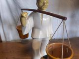 une figurine représentant un homme portant un panier de provisions sur l'épaule