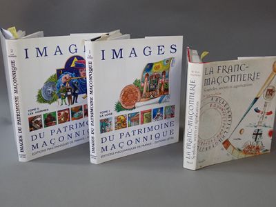 trois livres sont posés l'un à côté de l'autre sur une table