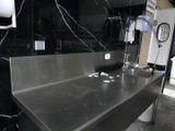 une photo d'un évier en acier inoxydable dans des toilettes publiques