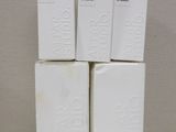 four white boxes of soap sitting on top of a white table