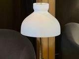 the lamp is on the table in the room by the chair