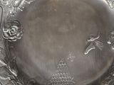 a silver plate with a bird and flower design on it