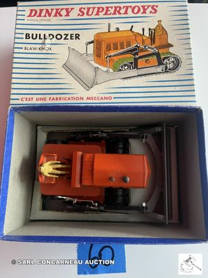 une boîte contenant un bulldozer miniature, posée sur une table