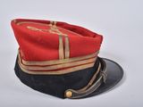 a red and black hat on a white surface