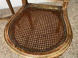 a wooden chair with a woven seat on a tiled floor