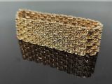 a close up of a gold bracelet on a black surface