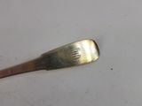 a silver spoon with a silver handle on a white surface