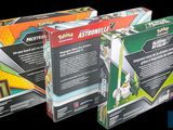three boxes of pokemon trading cards on a black background