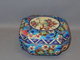 a small blue box with flowers on it on a table