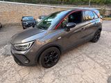 une voiture grise garée sur un parking, à côté d'un mur de briques