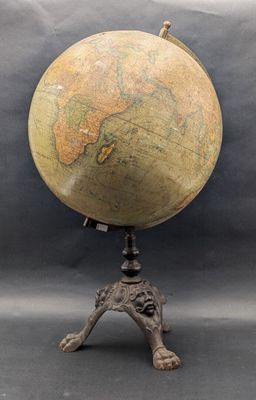 un vieux globe terrestre posé sur un trépied, avec un fond noir