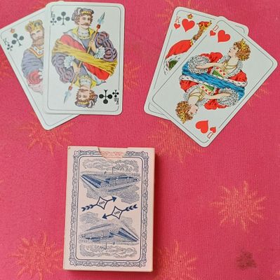 plusieurs cartes à jouer posées sur une table recouverte d'un napperon rose