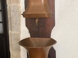 a tall wooden shelf with a metal bowl on it
