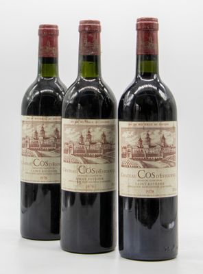 trois bouteilles de vin rouge posées l'une à côté de l'autre sur une surface blanche