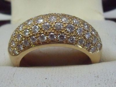une bague en or sertie de diamants blancs, posée sur un tissu blanc