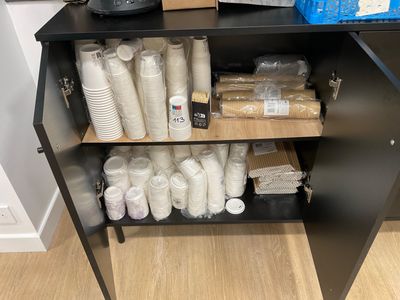 a black cabinet with a bunch of coffee cups on it