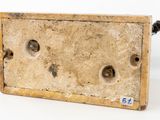 an old wooden box with holes in it sitting on a white surface