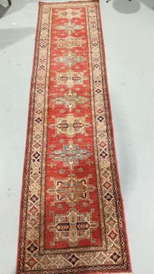 a long red rug on a white floor in a room