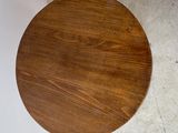 an image of a round wooden table on a concrete floor