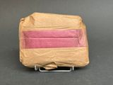 a piece of brown paper with a pink strip on top of it