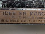 a plaque on the side of a black marble table