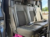 the back seats of a van with the door open and a pink towel in the passenger seat