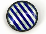un gros plan d'un bouton rayé bleu et blanc sur une surface blanche