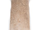 a stone vase on a metal stand on a white surface