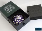 a purple and white object in a black box
