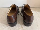 pair of brown leather shoes with laces on them on a marble floor