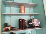 a shelf with books, a vase, and other items on it
