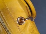 yellow leather handbag with a zipper on the inside of it