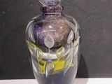 un vase en verre orné d'un motif violet et jaune