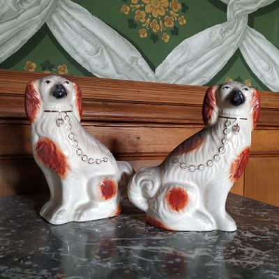 deux chiens en céramique assis sur une table