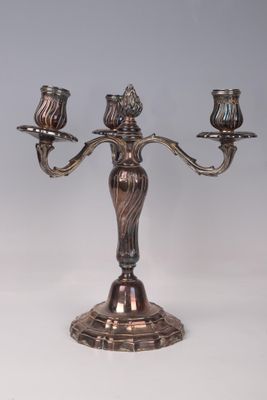 a metal candelab with three candles on it