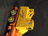 a yellow toy truck that is sitting on a black surface