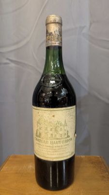 an old bottle of wine sitting on top of a wooden table