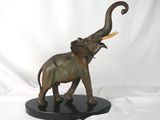 statue d'un éléphant avec des défenses, posée sur un socle noir