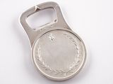 silver bottle opener with a silver medal on it on a white surface