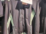 trois vestes suspendues à un portant dans un magasin