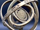 a metal sculpture of a sundial with a coin on it
