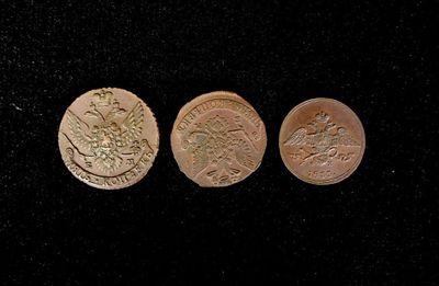 three different types of gold coins on a black surface