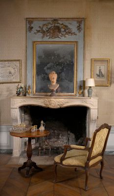 un tableau accroché au mur au-dessus de la cheminée d'une pièce
