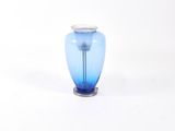 un vase en verre bleu avec un socle en argent sur fond blanc