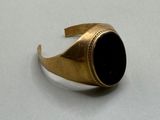an image of a gold ring with a black stone in it